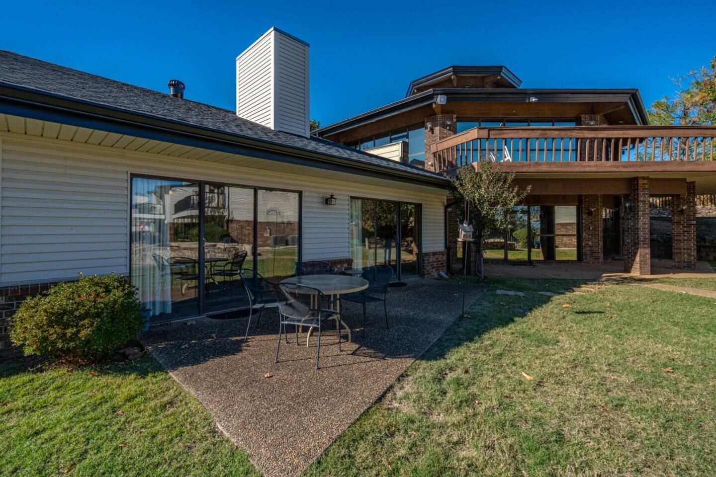 A large house with a patio and a table and chairs in front of it.