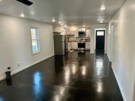 There is a ceiling fan in the hallway leading to the kitchen.