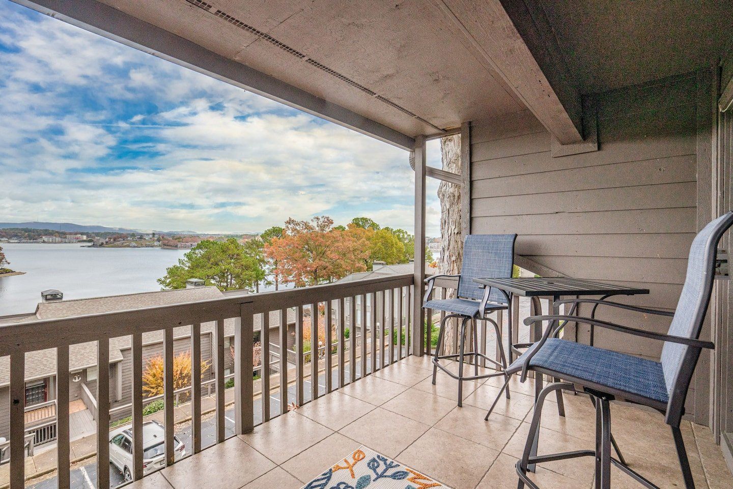 A balcony with a table and chairs overlooking a body of water.
