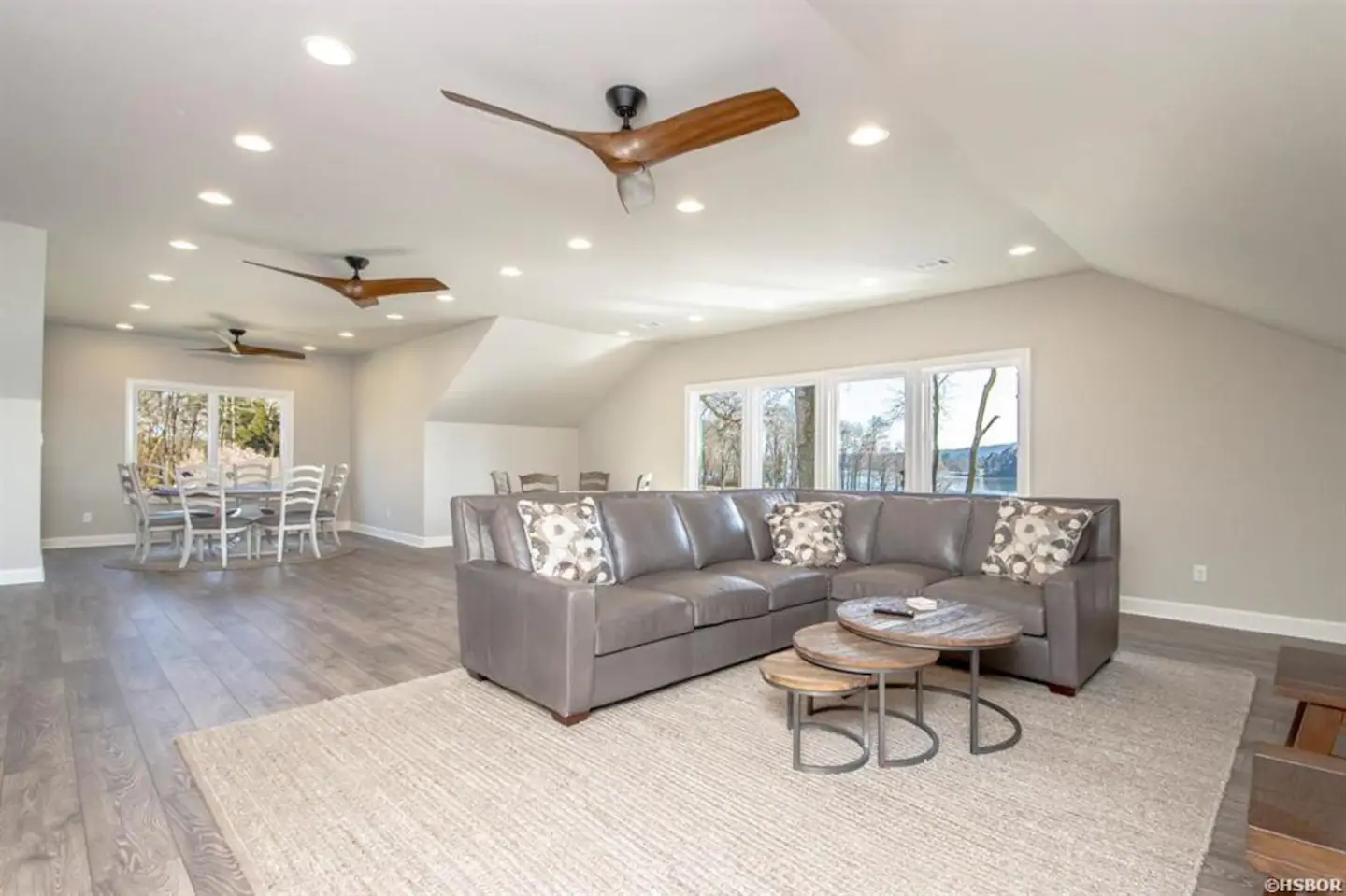 A living room with a couch , table and ceiling fan.