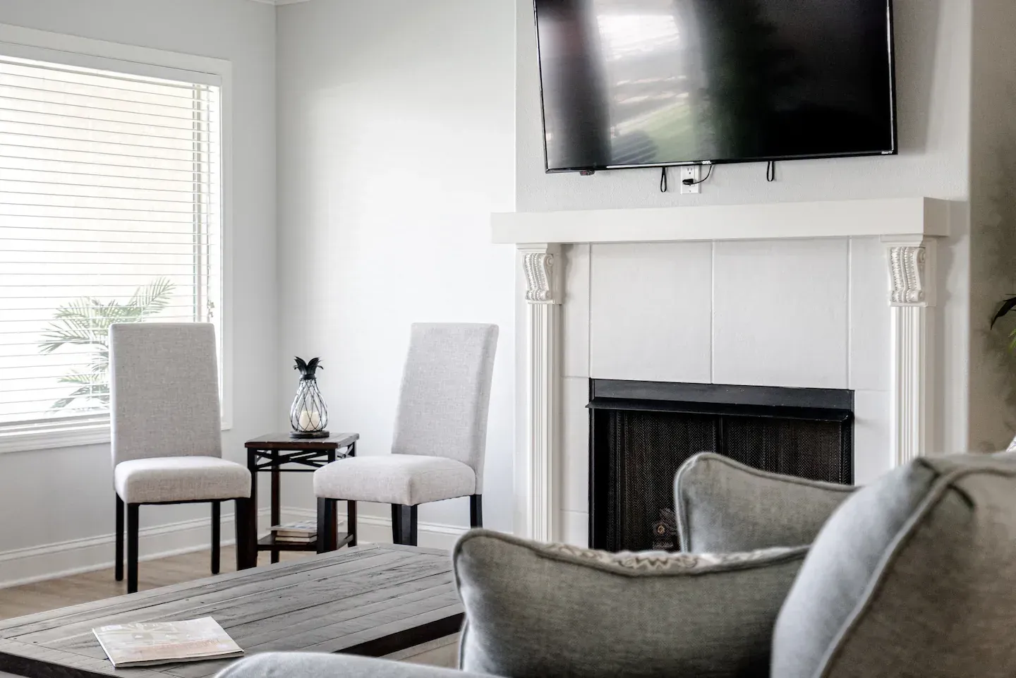 A living room with a fireplace and a flat screen tv on the wall.