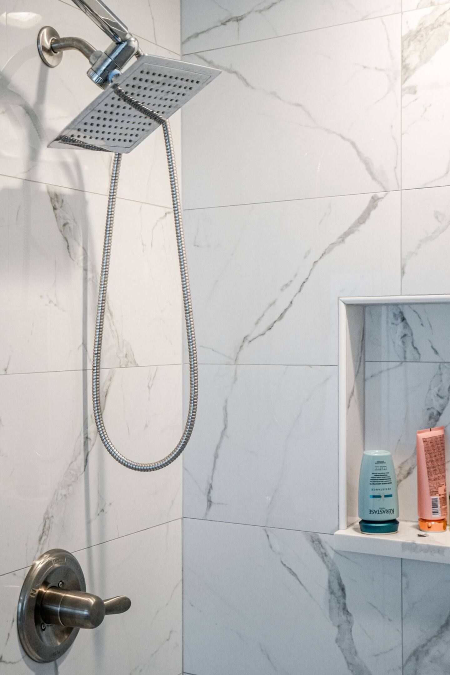 A shower head is hanging from the wall in a bathroom.