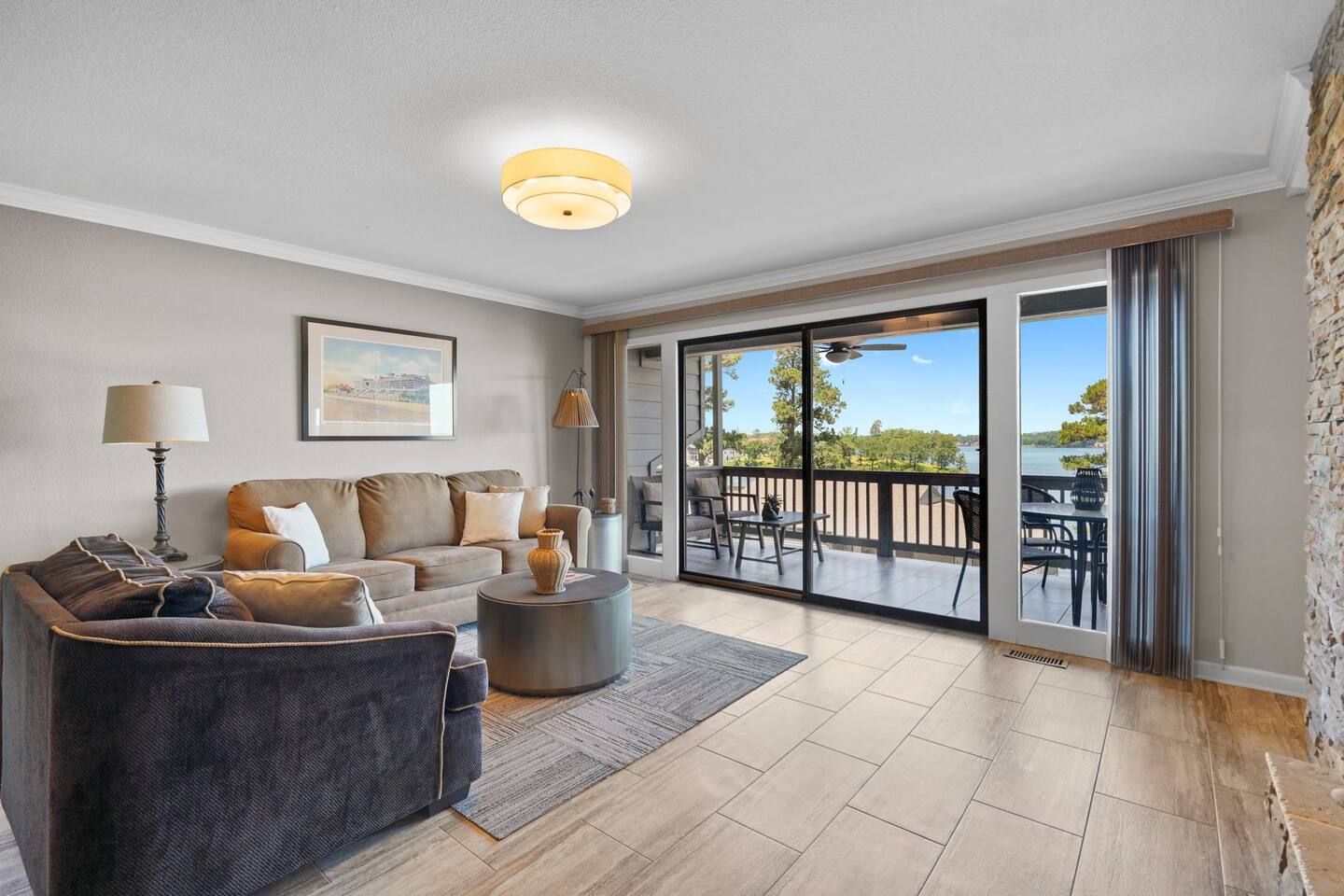 A living room with a couch , chair , table and sliding glass doors.