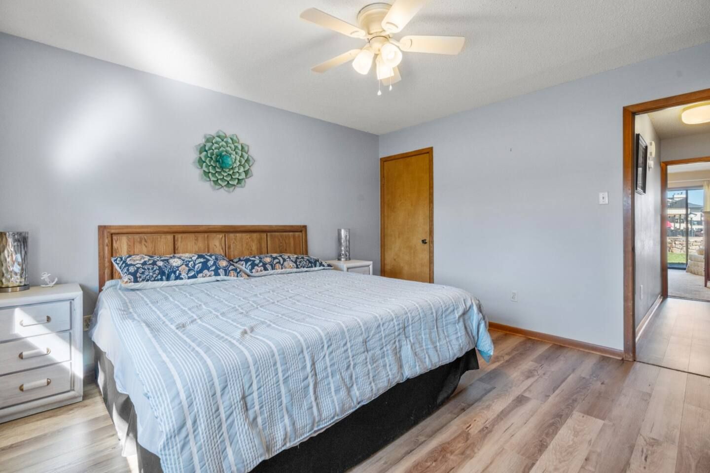 A bedroom with a king size bed and a ceiling fan.