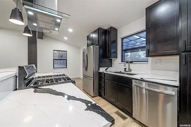 A kitchen with black cabinets and stainless steel appliances.