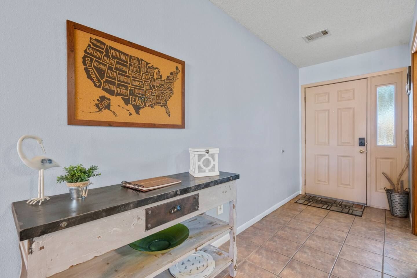 A hallway with a table and a map of the united states on the wall.