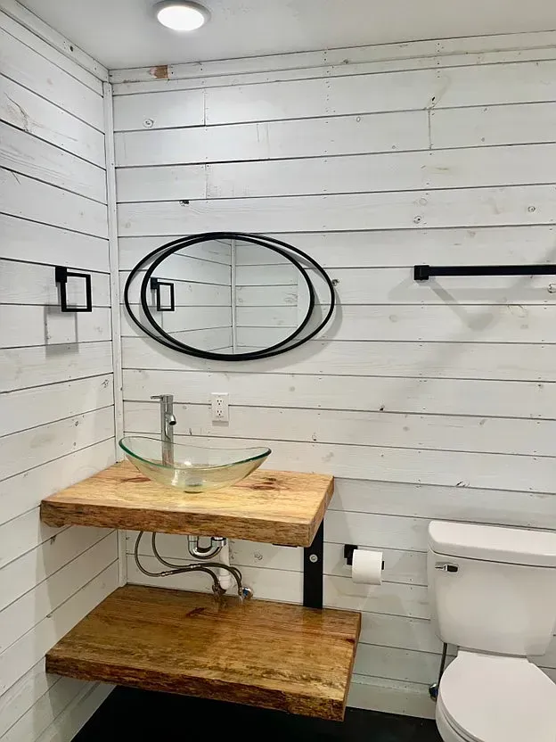 A bathroom with a sink , toilet and mirror.
