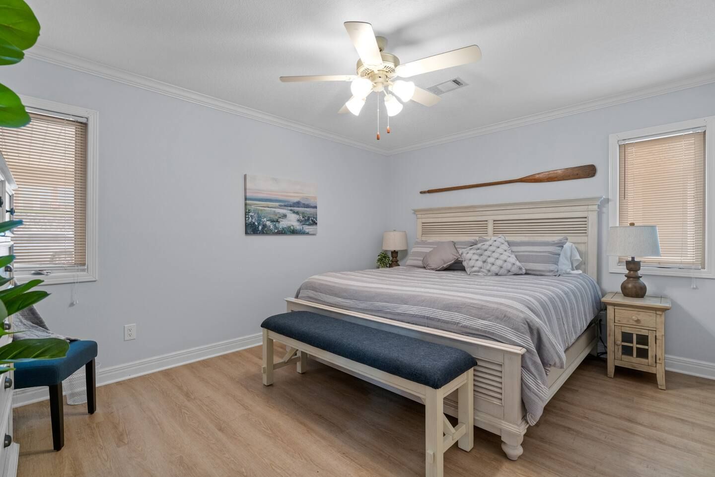A bedroom with a king size bed and a ceiling fan.
