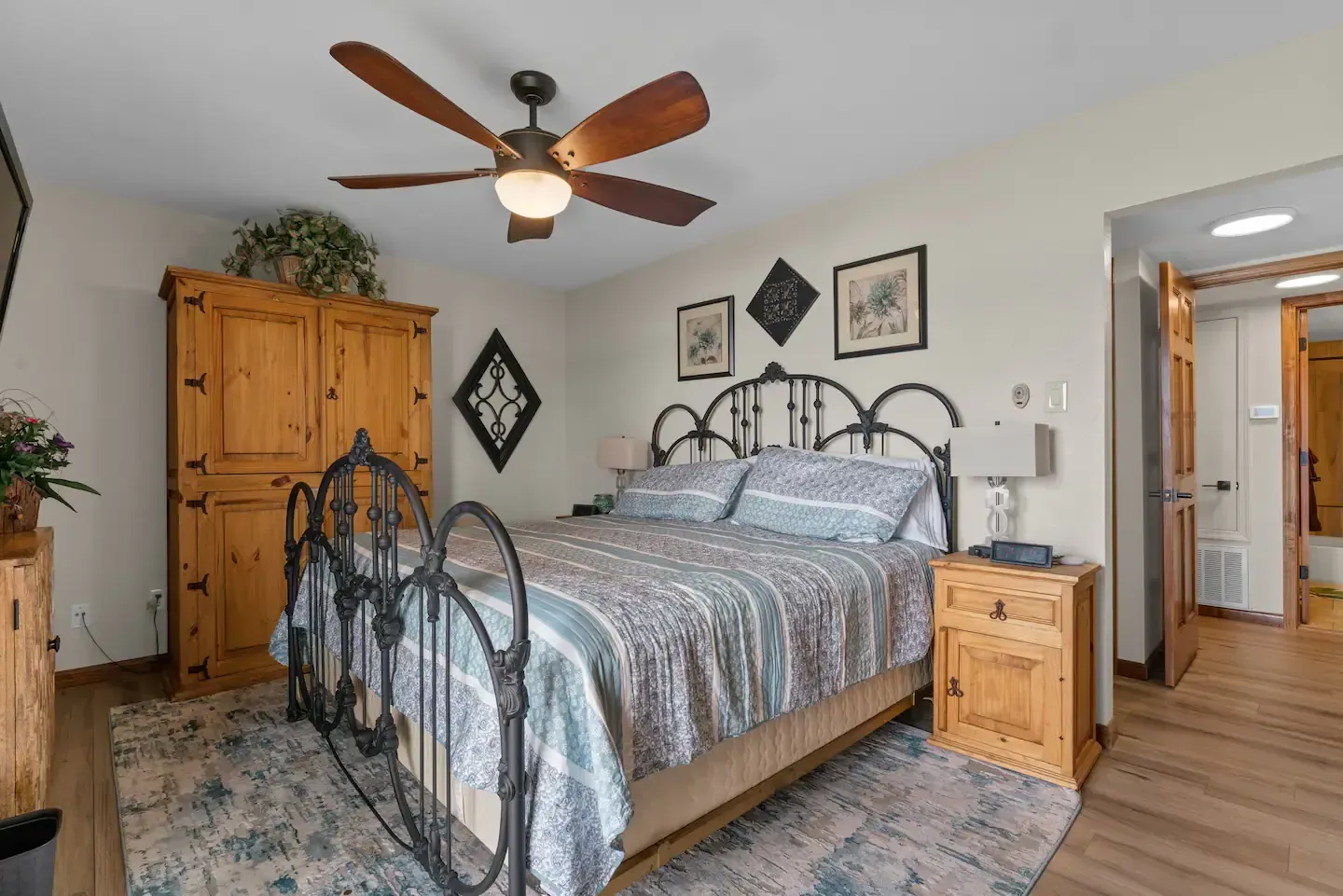 A bedroom with a king size bed and a ceiling fan.
