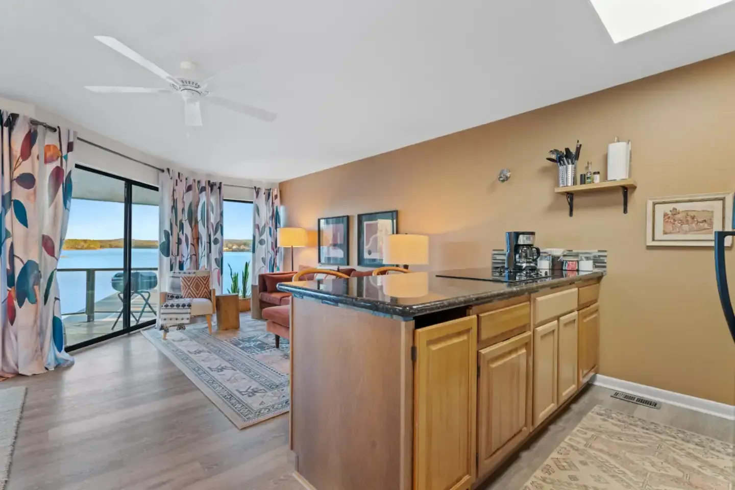 A living room with a kitchen and a view of the ocean.