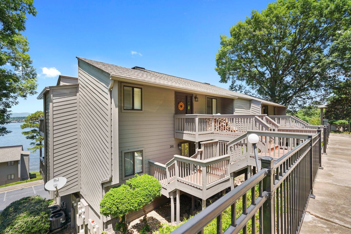 A large apartment building with a balcony overlooking a lake.
