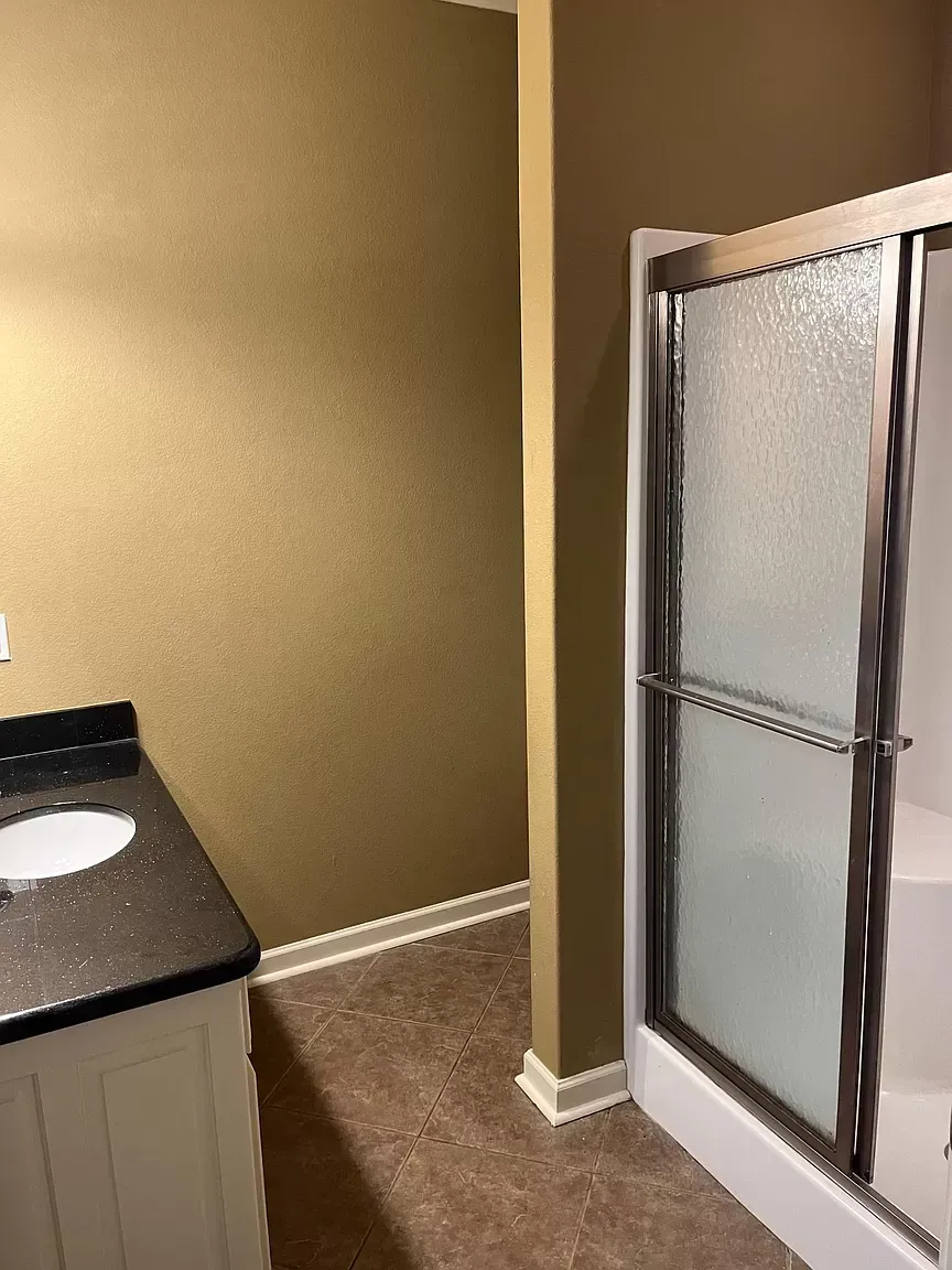 A bathroom with a sink and a shower.