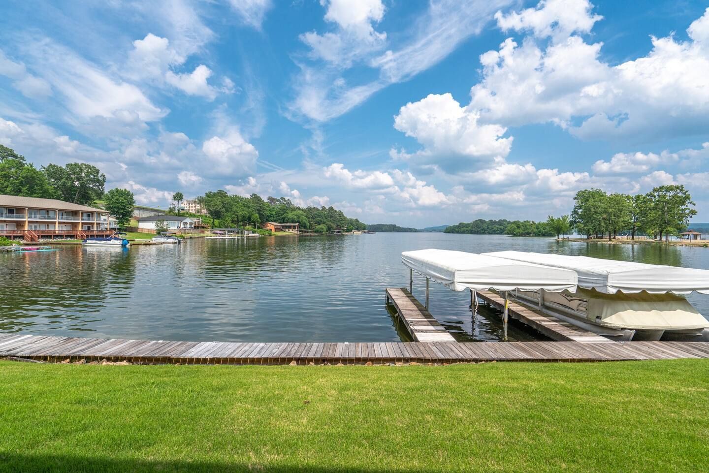 A lake with a dock and boats in it on a sunny day.