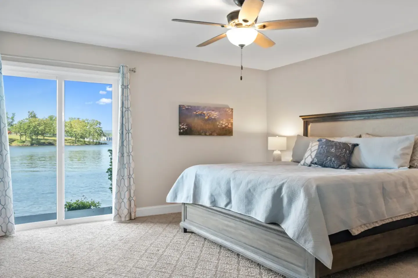 A bedroom with a king size bed and a ceiling fan.