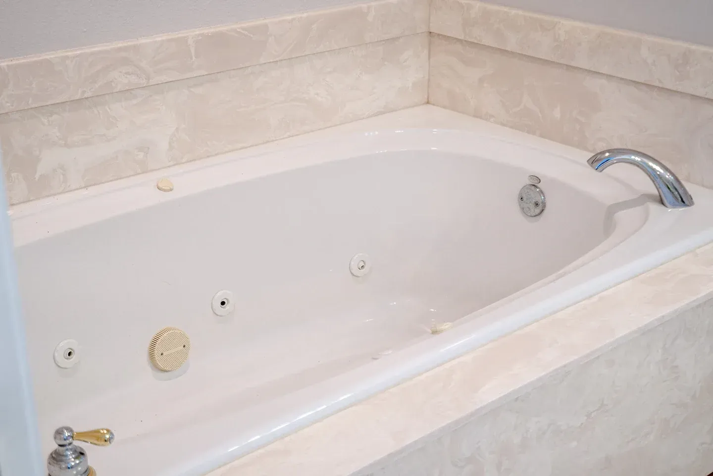 A white bathtub with a faucet in a bathroom.