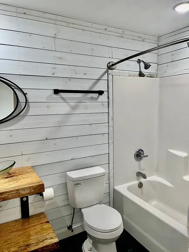 A bathroom with a toilet , sink , and bathtub.