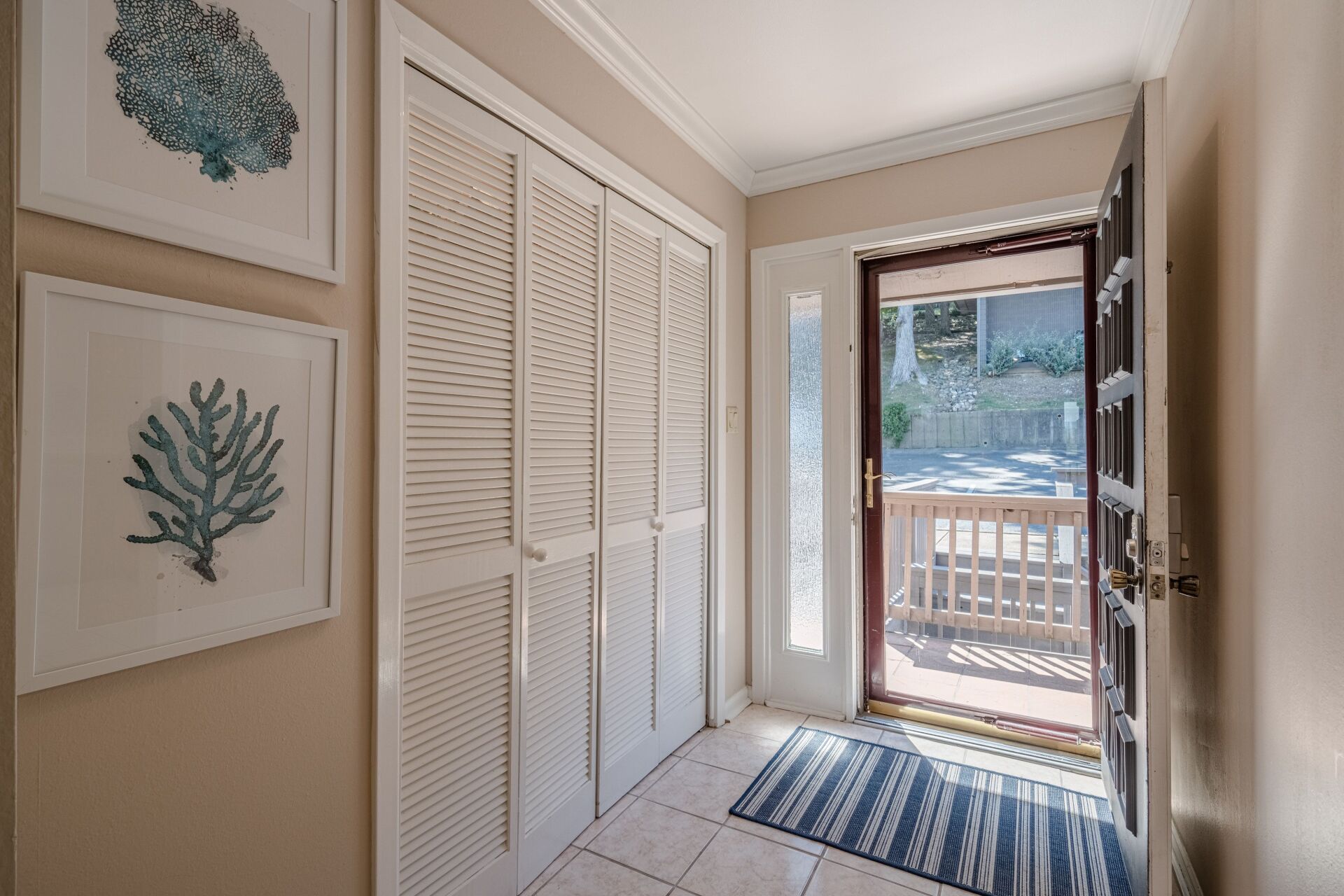 A hallway with a door that is open and a rug on the floor.
