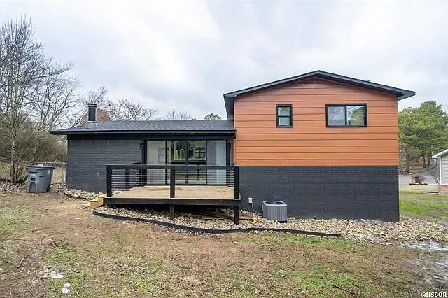 The back of a house with a deck and a lot of windows.