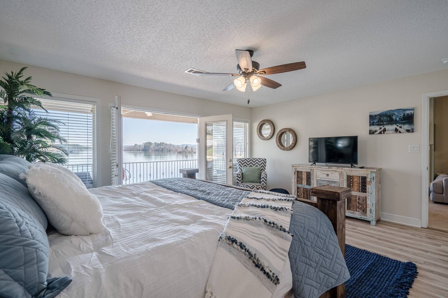 A bedroom with a king size bed and a ceiling fan.