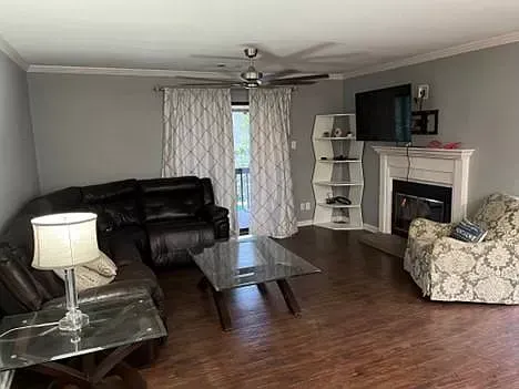 A living room with a couch , chair , coffee table , fireplace and television.