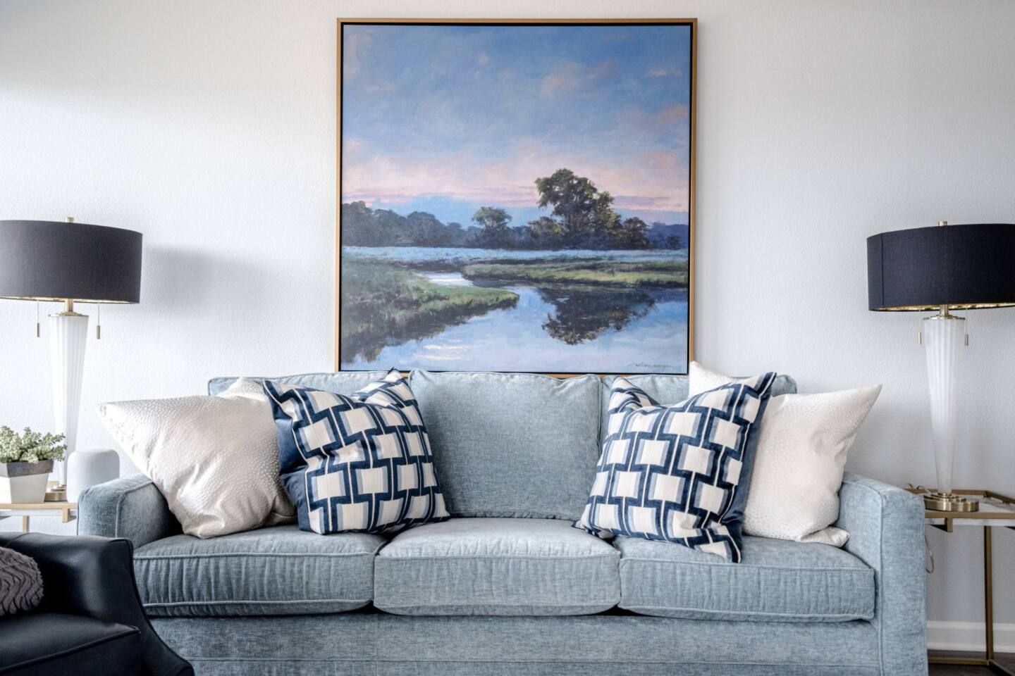 There is a painting on the wall above the couch in the living room.