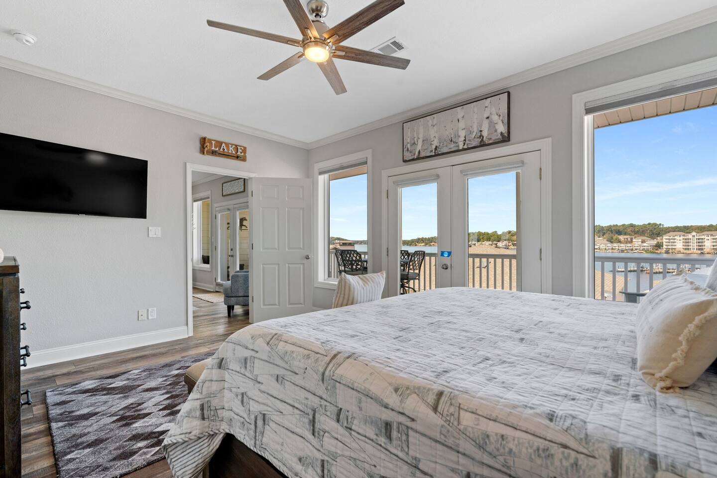 A bedroom with a king size bed , a flat screen tv , and a ceiling fan.