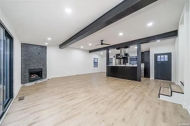 A large empty living room with hardwood floors and a fireplace.