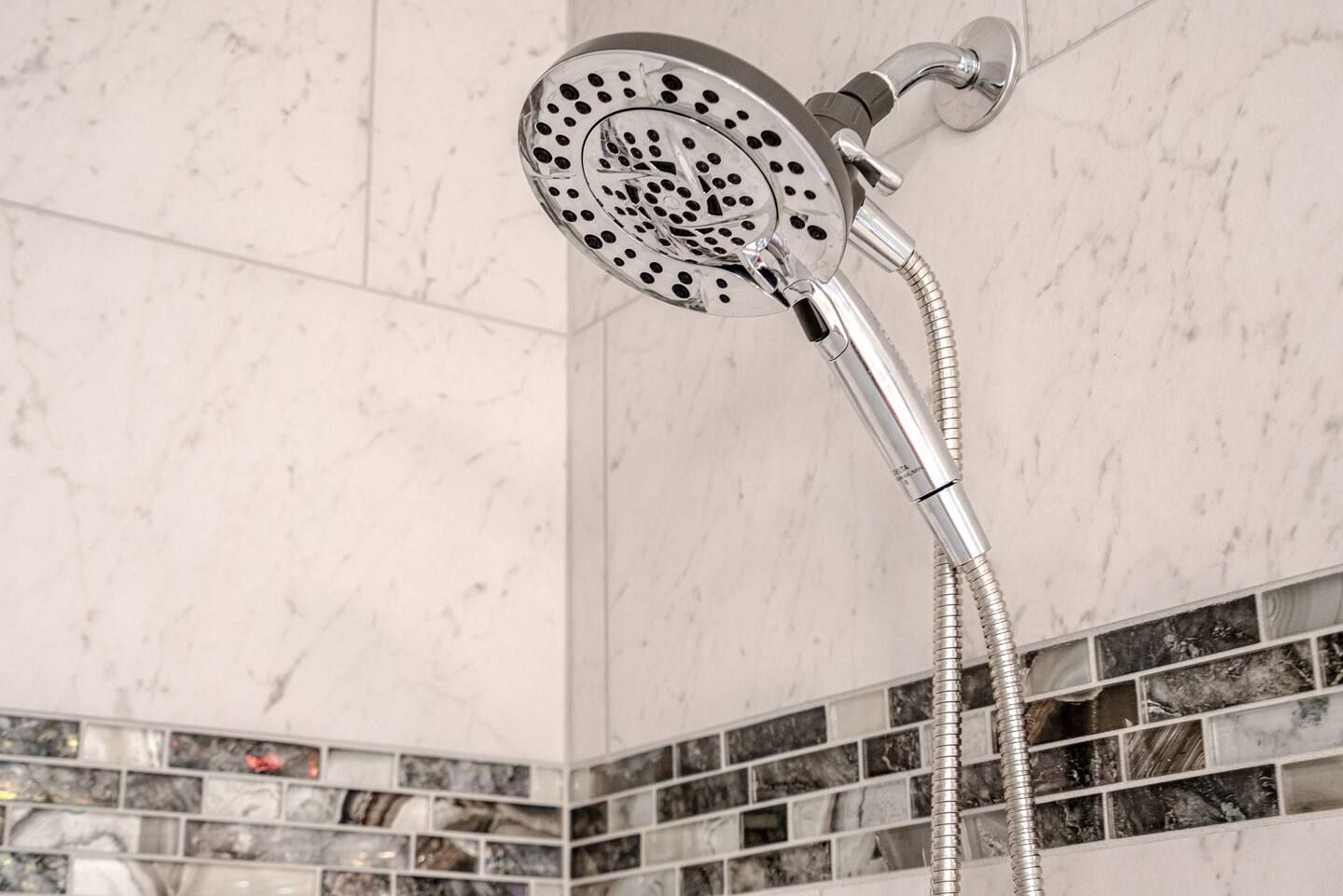 A close up of a shower head in a bathroom.