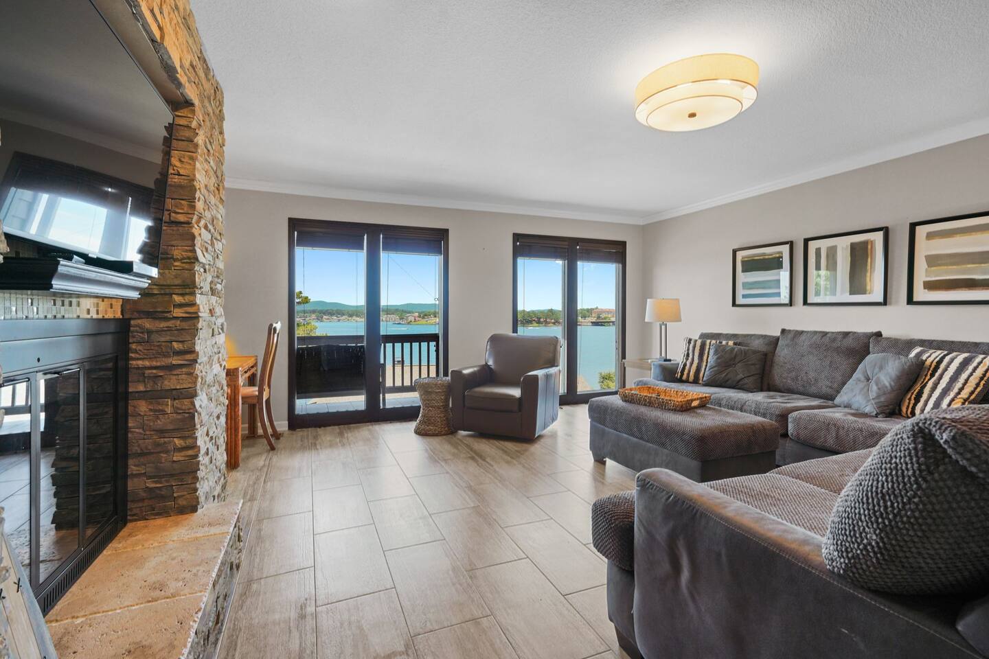 A living room with a couch , chair , fireplace and lots of windows.