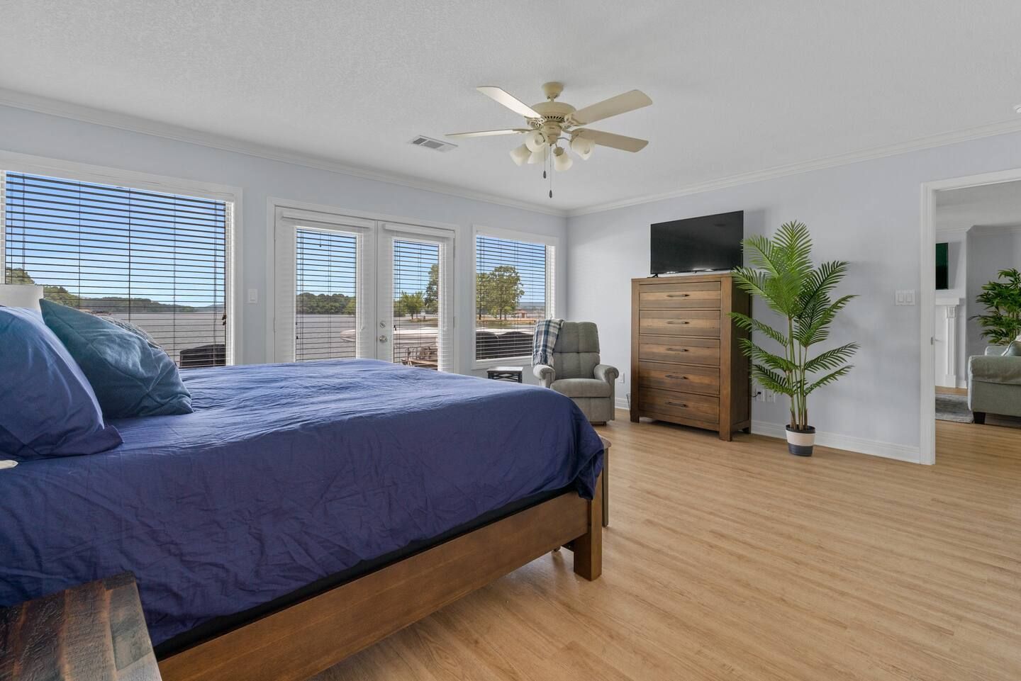 A bedroom with a king size bed , dresser , chair and television.
