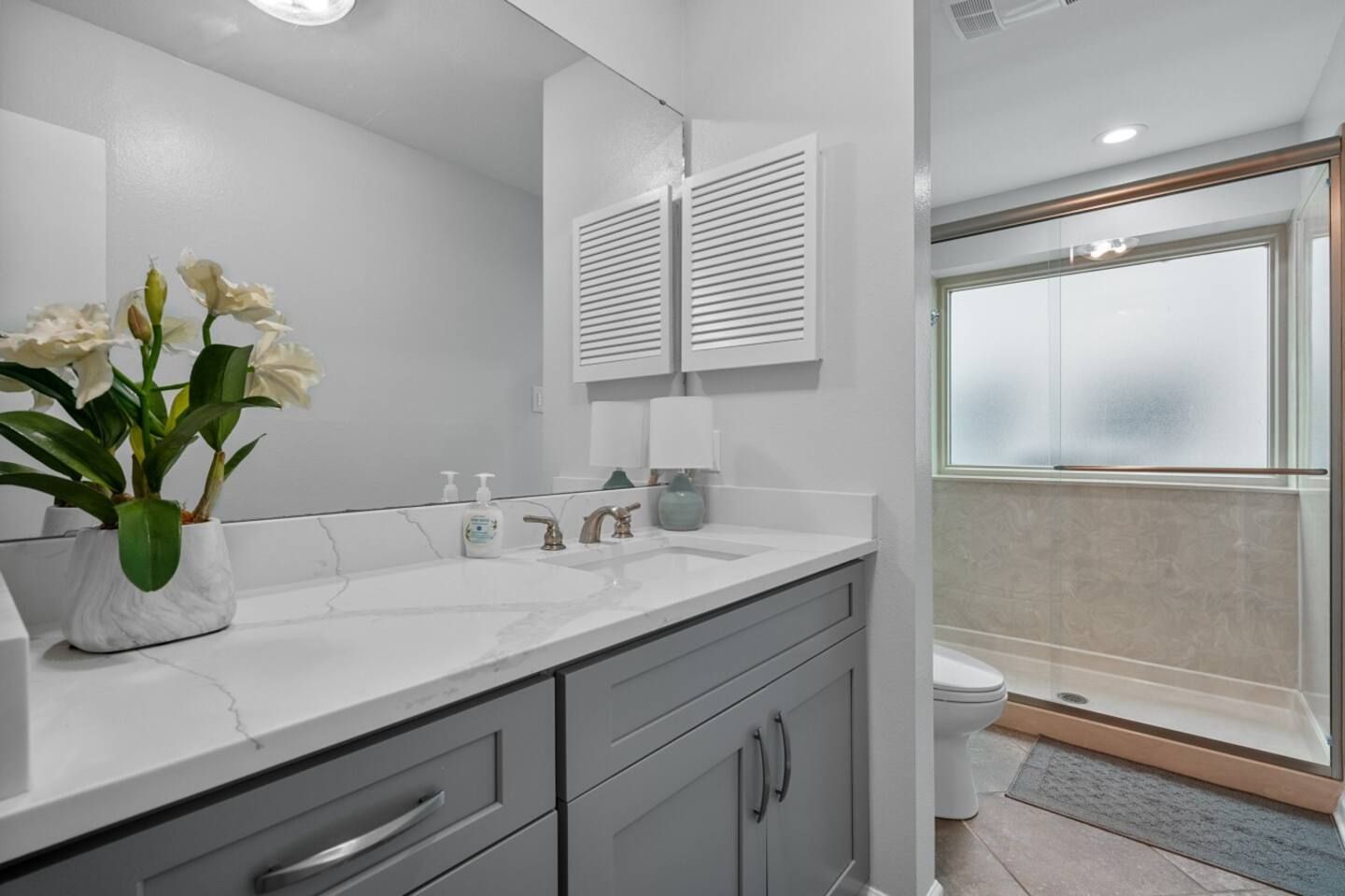 A bathroom with a sink , mirror and toilet.