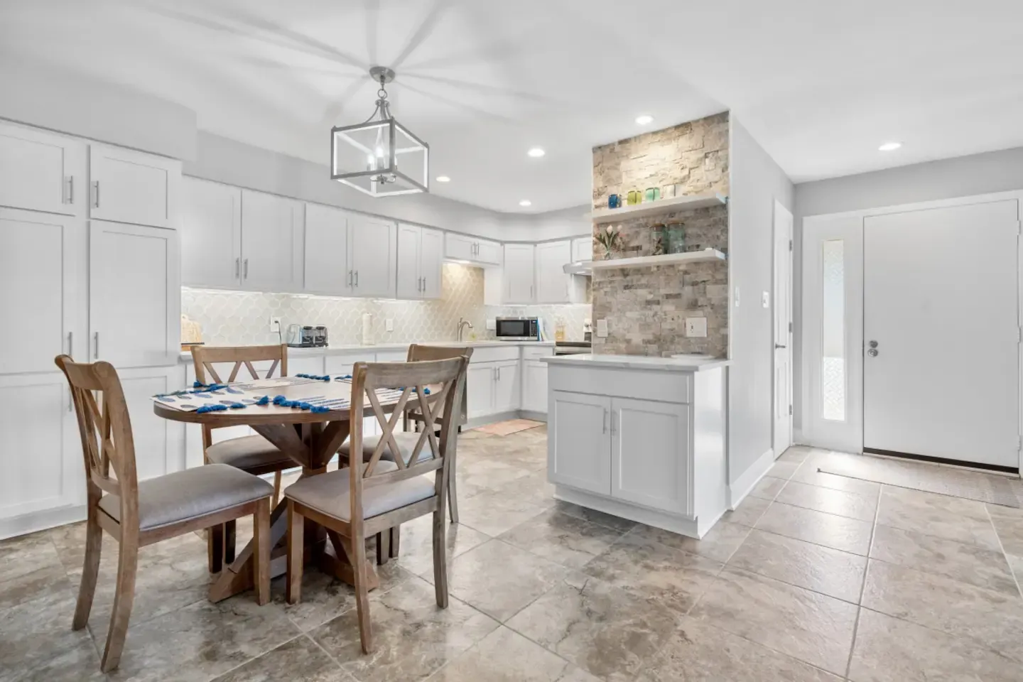 A kitchen with a dining table and chairs in it.