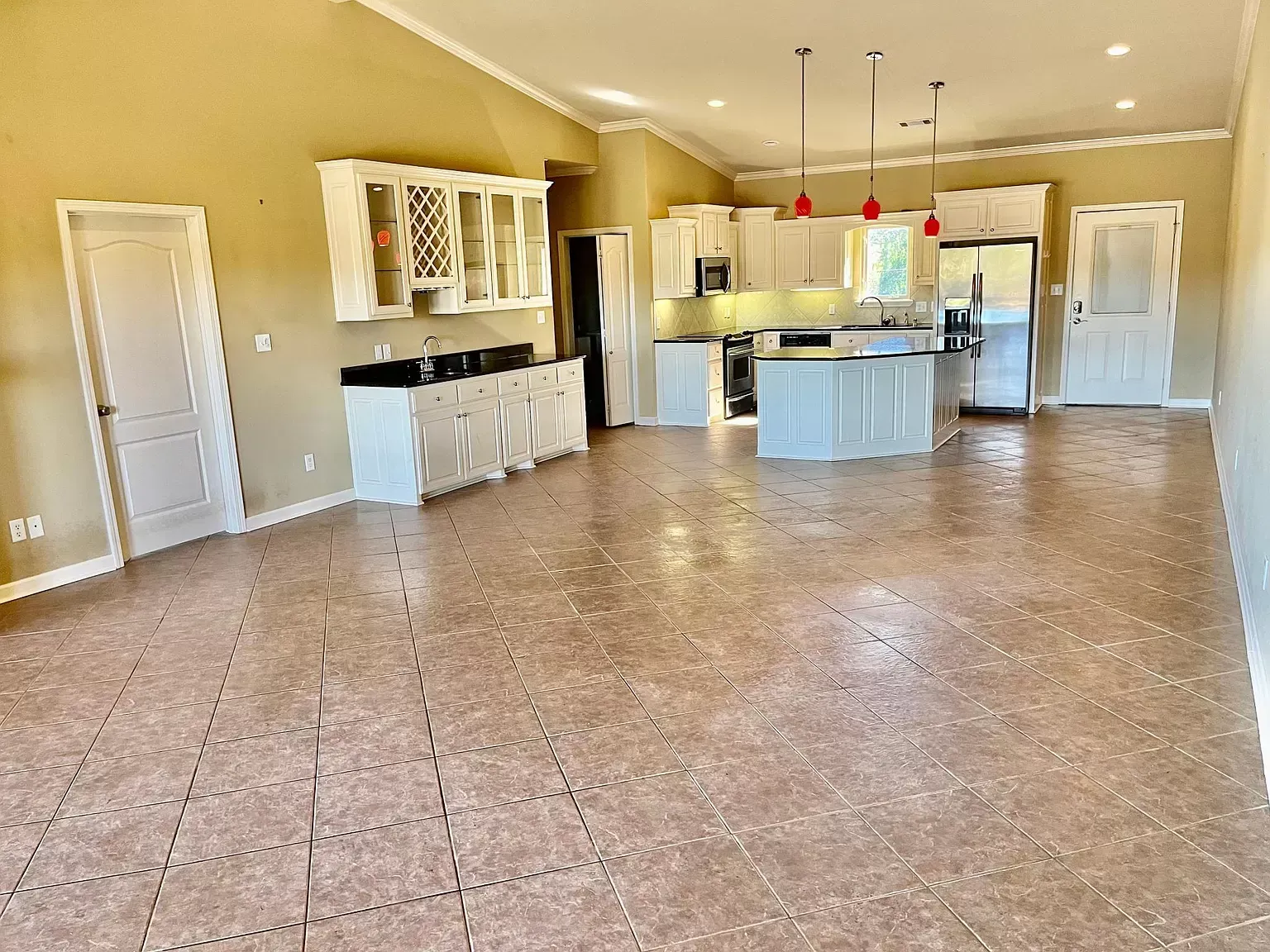 A large room with a kitchen and a tiled floor