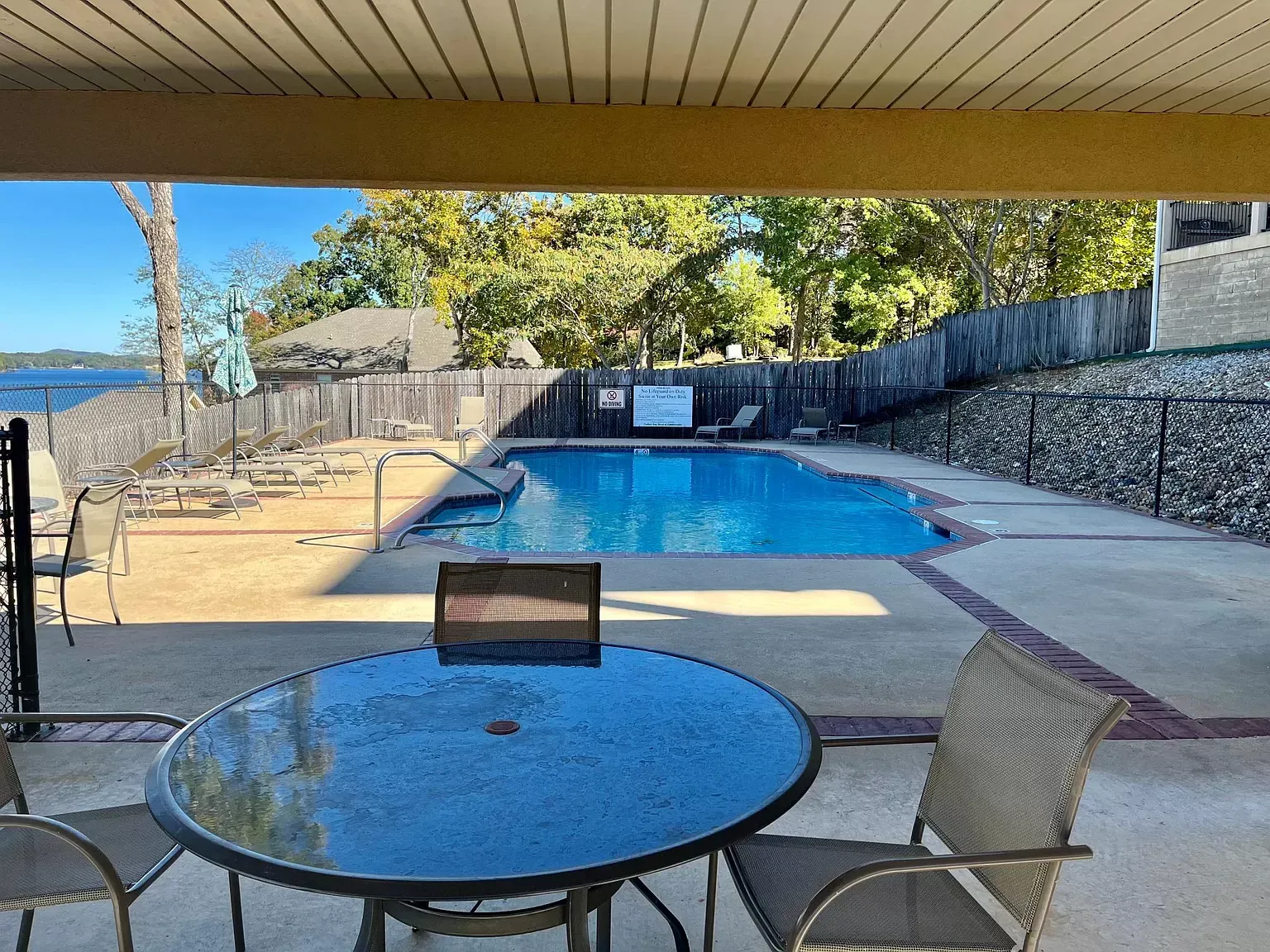 A swimming pool with a table and chairs in front of it