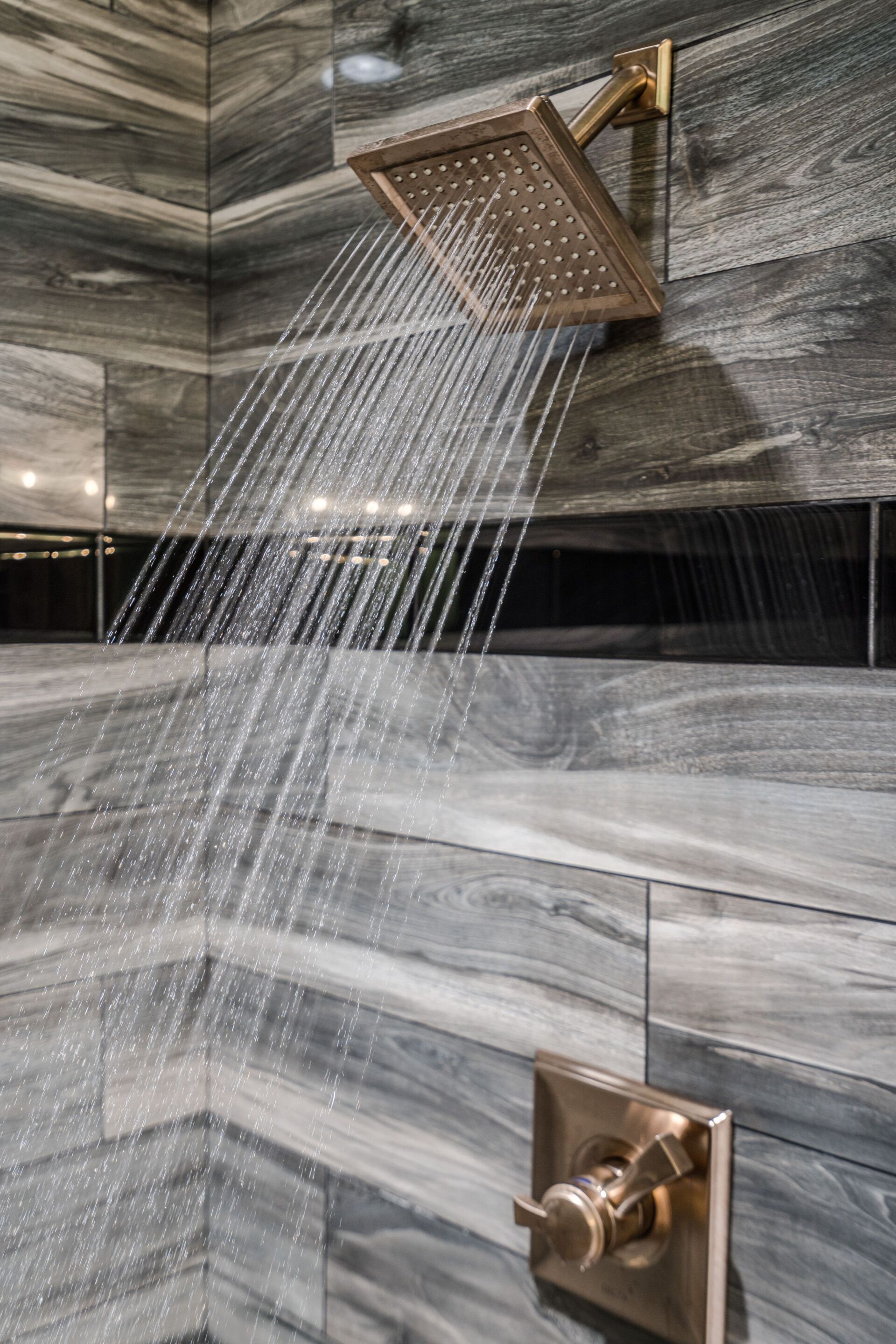 A shower head is spraying water in a bathroom.