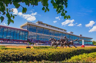 Race track building with large windows and a statue of horses.