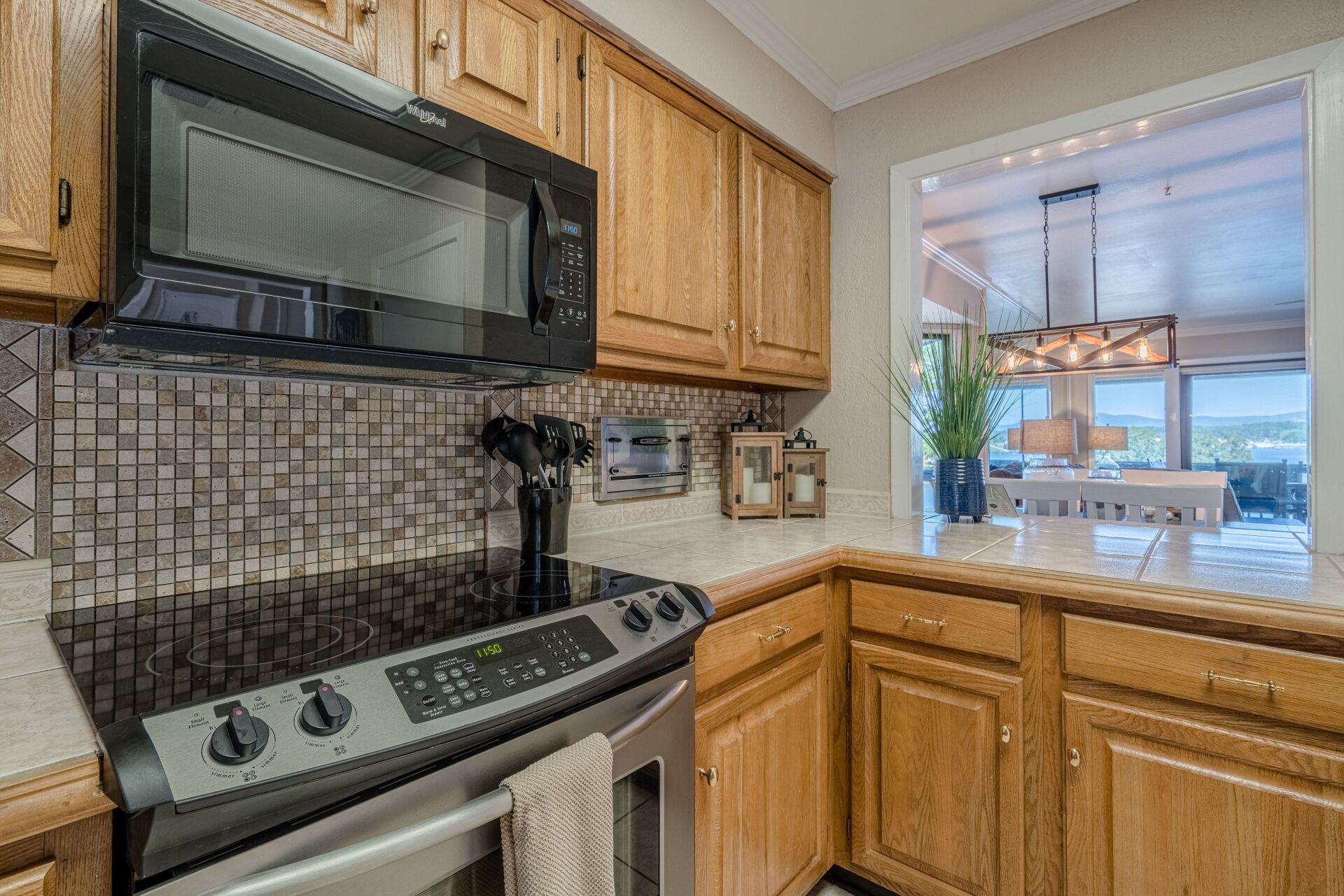 A kitchen with a stove , microwave , and cabinets.