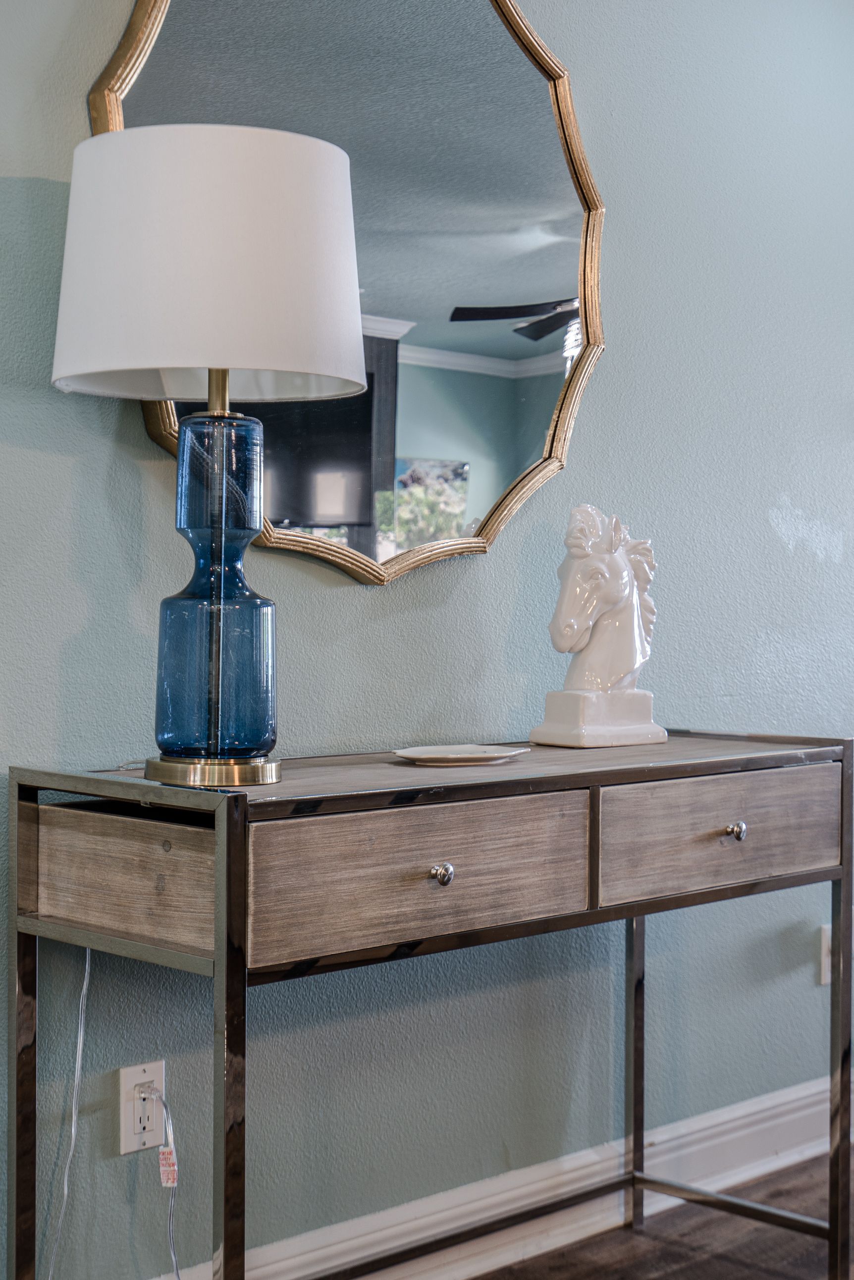A table with a lamp and a mirror on it