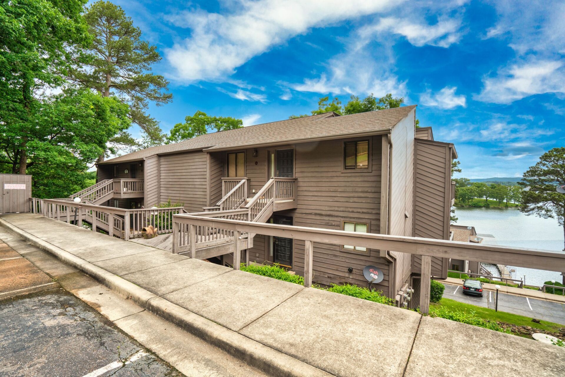 A large apartment building with a balcony overlooking a lake.