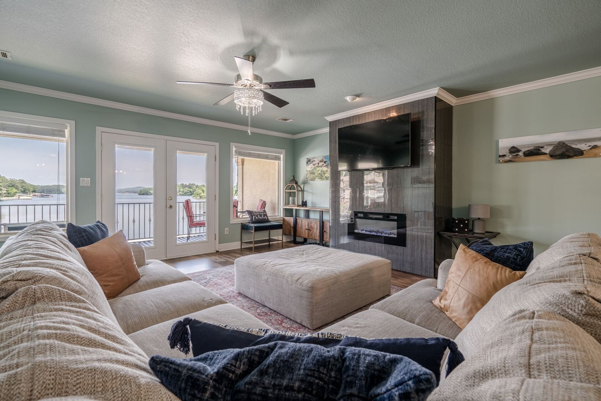 A living room with a couch , fireplace , television and ceiling fan.