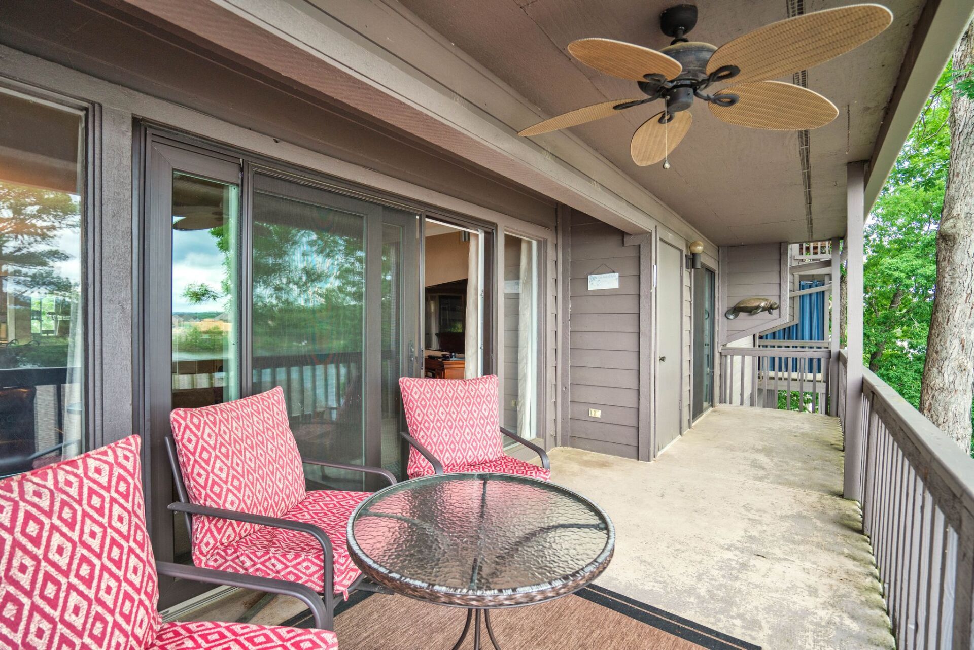 A balcony with a table and chairs and a ceiling fan.