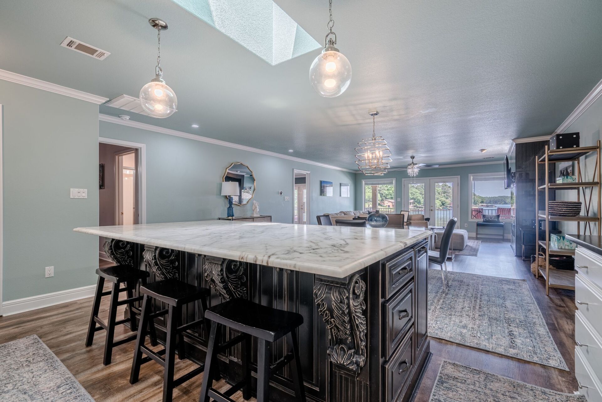 A kitchen with a large island and stools in a house.