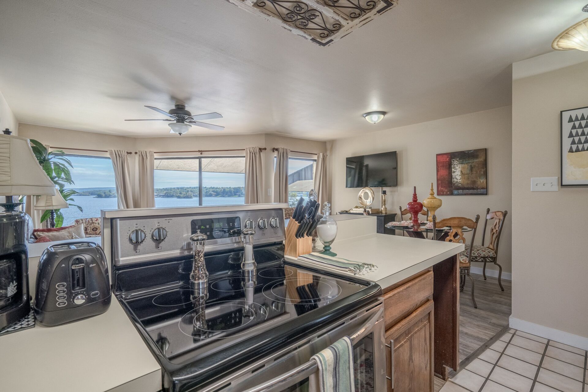 A kitchen with a stove , sink , and ceiling fan.
