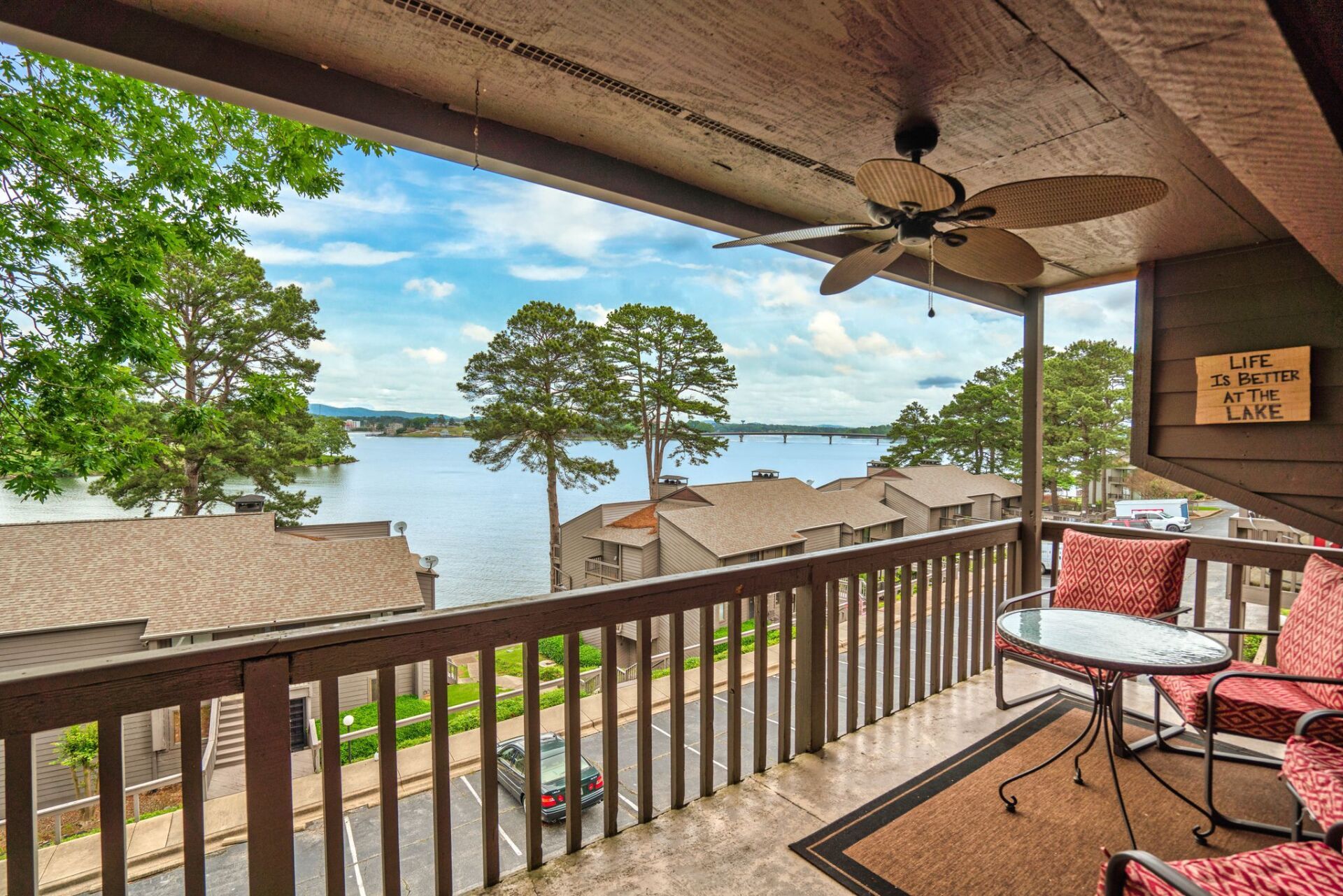 A balcony with a view of a lake and a ceiling fan.