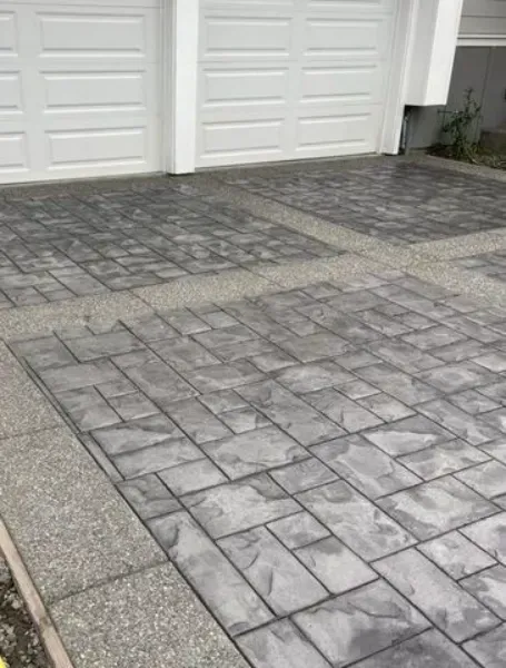 A concrete driveway with a garage door in the background.