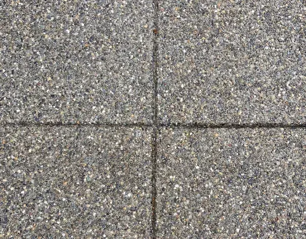 A close up of a gray tile floor with a cross in the middle.