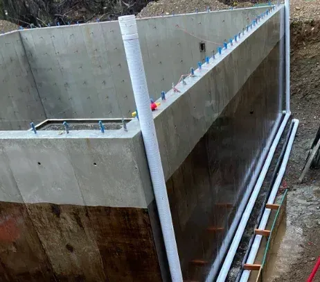A large concrete wall is being built in a basement.