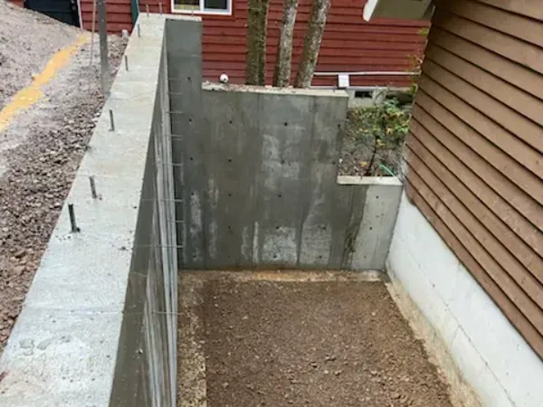 A concrete wall is being built next to a house.