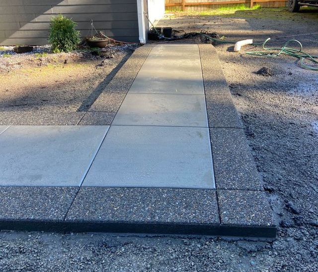 A concrete walkway is being built in front of a house.