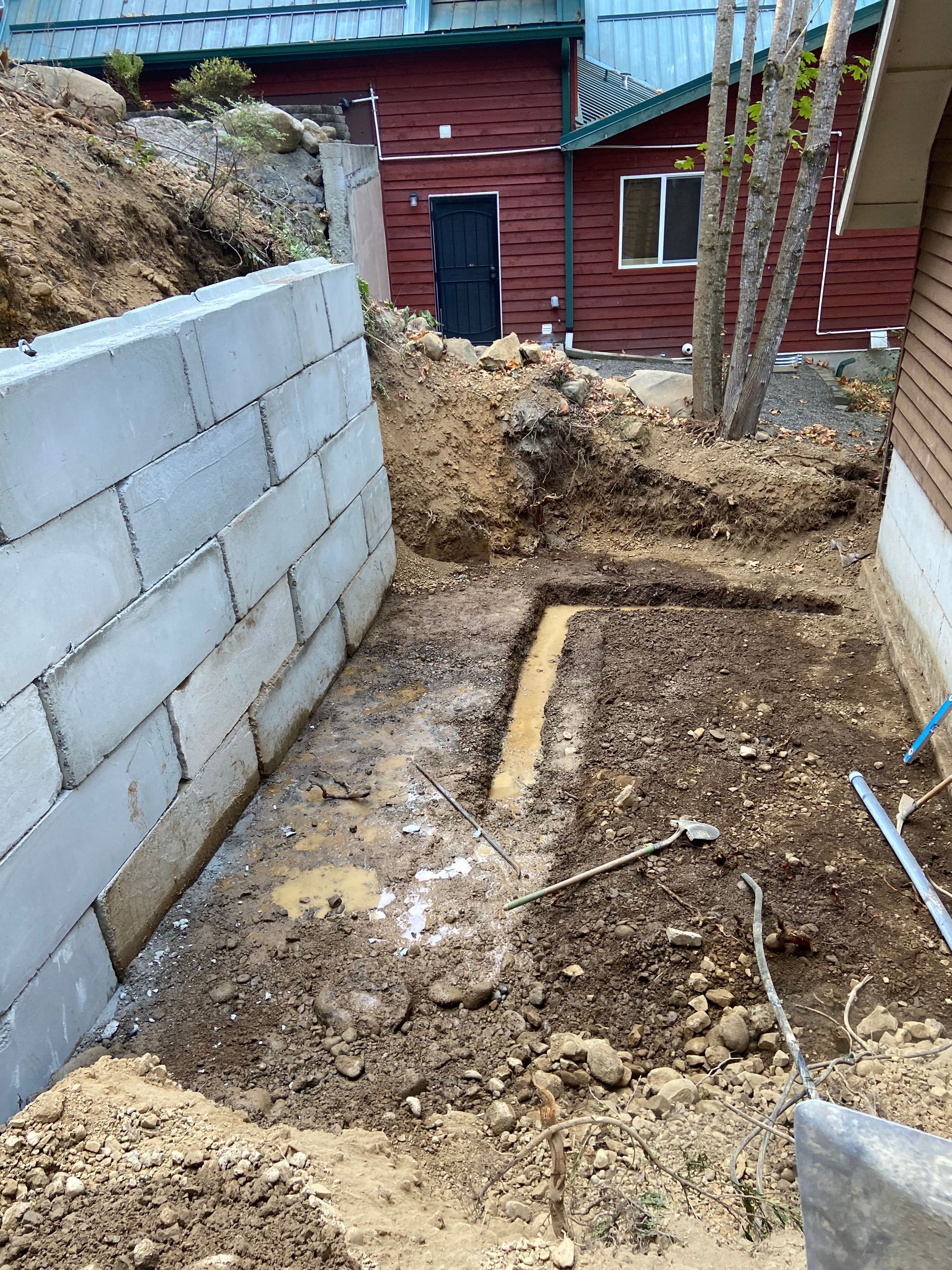 A brick wall is being built in the backyard of a house.